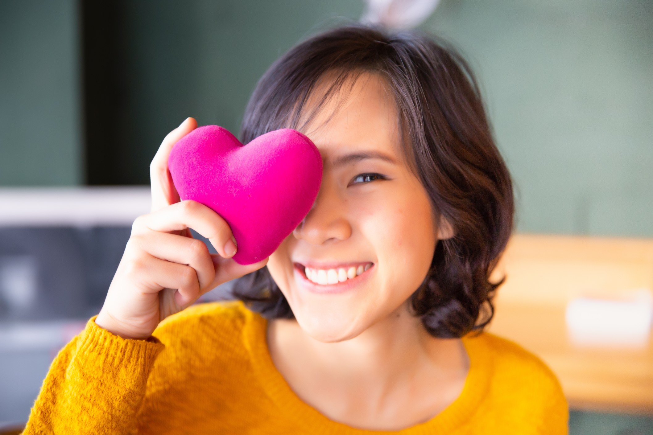 portrait-of-young-woman-in-yellow-sweater-holding-pink-heart-people-age-family-love-heart-healthcare_t20_W7yrbm